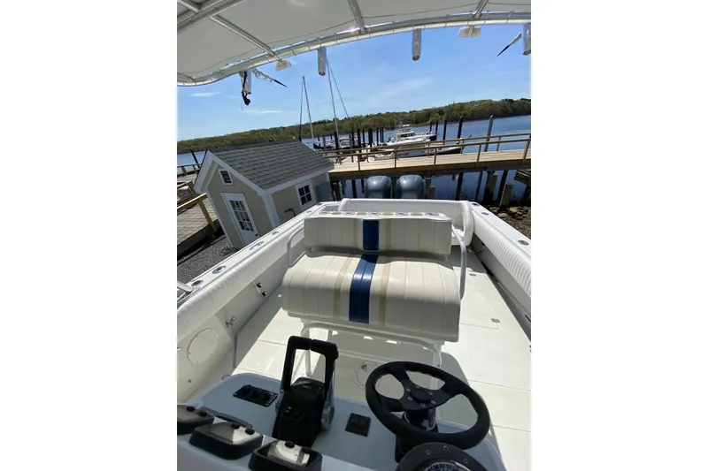 Slide: The Image of 1996 Intrepid 337 boat interior with steering wheel, dock, and waterfront view. - 20