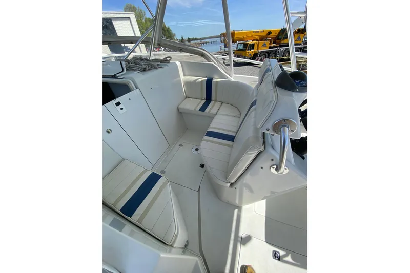 Slide: The Image of 1996 Intrepid 337 boat interior with white and blue seating, docked near water. - 21