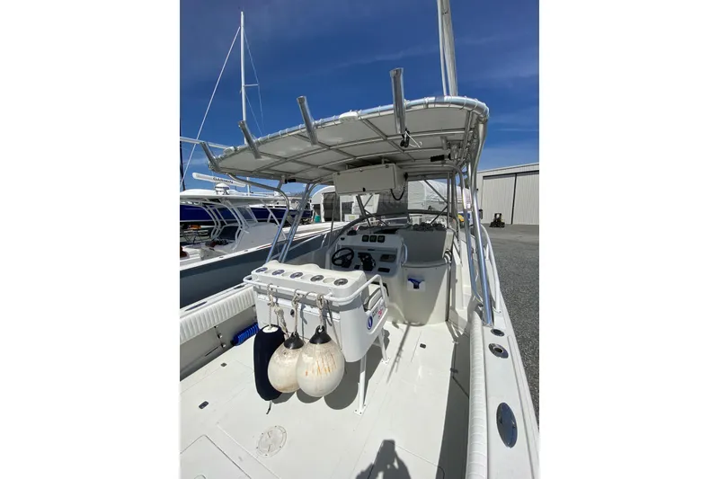 Slide: The Image of 1996 Intrepid 337 boat interior with helm, rod holders, and fenders under a clear blue sky. - 25