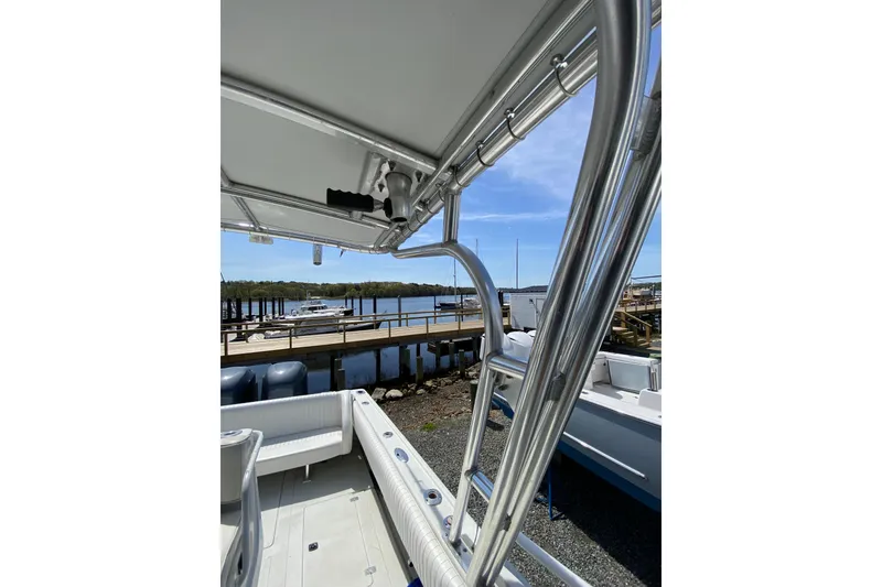 Slide: The Image of 1996 Intrepid 337 boat with stainless steel frame, docked by a scenic waterfront. - 26