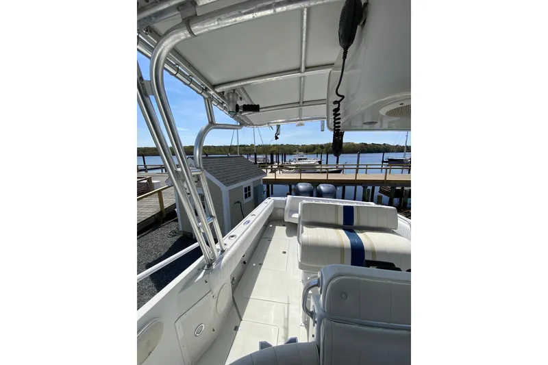 Slide: The Image of 1996 Intrepid 337 boat interior with seating, docked by a scenic waterfront. - 30