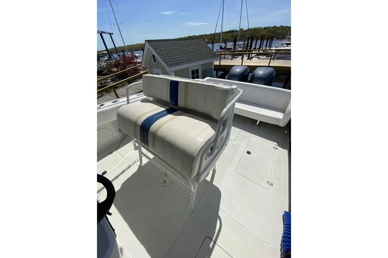 Slide: The Image of 1996 Intrepid 337 boat interior with cushioned seating and dock view. - 33