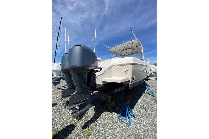 Slide: The Image of 1996 Intrepid 337 boat on stands, featuring dual outboard motors, under a clear blue sky. - 4