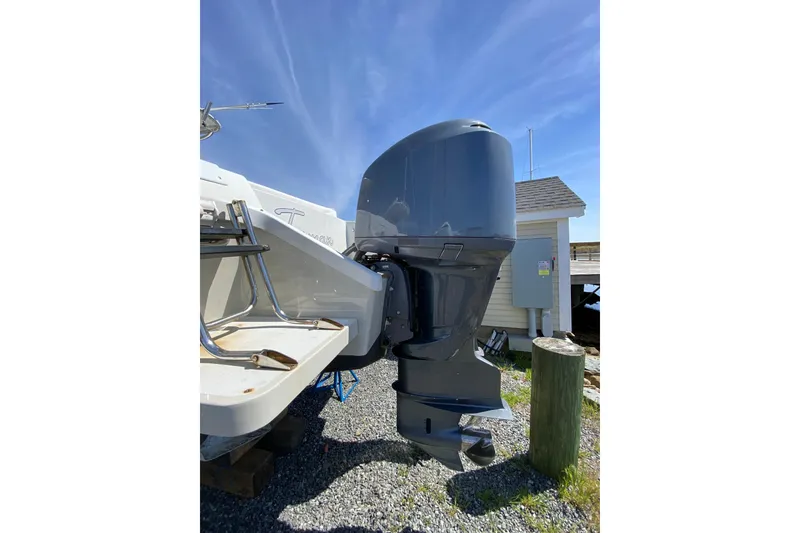 Slide: The Image of 1996 Intrepid 337 boat with powerful outboard motor, docked on gravel surface. - 41