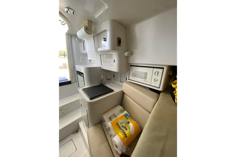 Slide: The Image of 1996 Intrepid 337 boat interior with kitchenette, microwave, and seating area. - 46