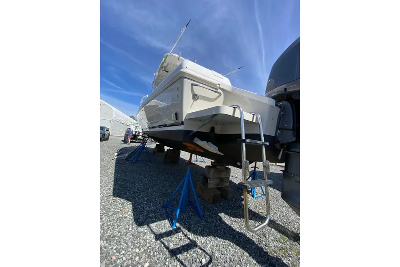 Slide: The Image of 1996 Intrepid 337 boat on stands, ladder visible, under clear blue sky. - 6