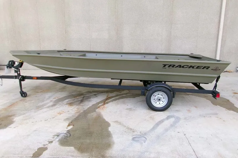 The Image of 2026 Tracker Grizzly 1648 Utility boat on trailer, parked on concrete surface. - 0