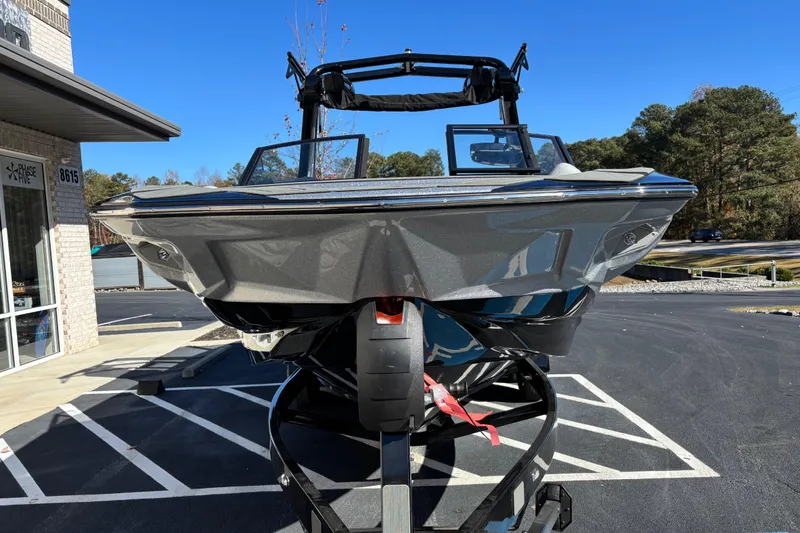 Slide: The Image of 2026 Centurion Nv243 boat on trailer, parked outside a building on a sunny day. - 3