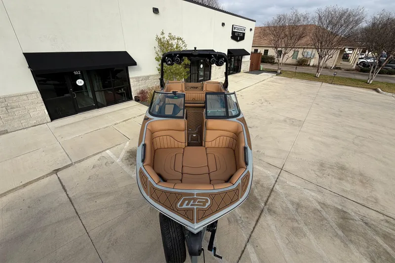 Slide: The Image of 2026 MB B52 21 Alpha boat with tan interior, parked outside a building. - 23