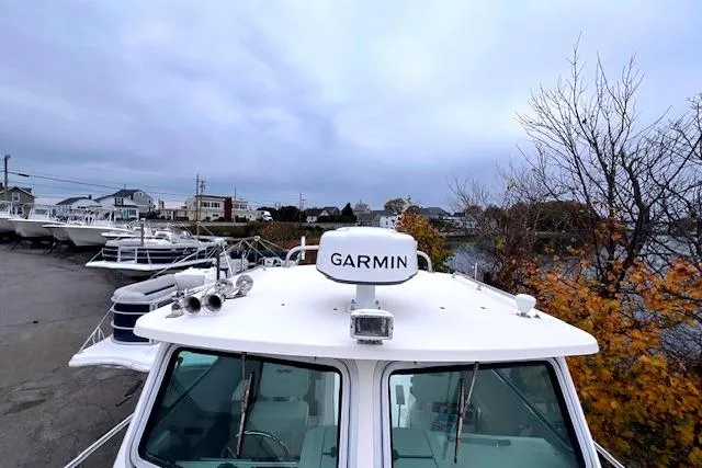 Slide: The Image of 2005 Parker 2520 Modified Vee Sport Cabin with Garmin equipment, docked near autumn foliage. - 4
