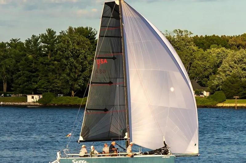 Slide: The Image of Sailing boat Wraceboats GP26 2015 on a serene lake with lush green background. - 1
