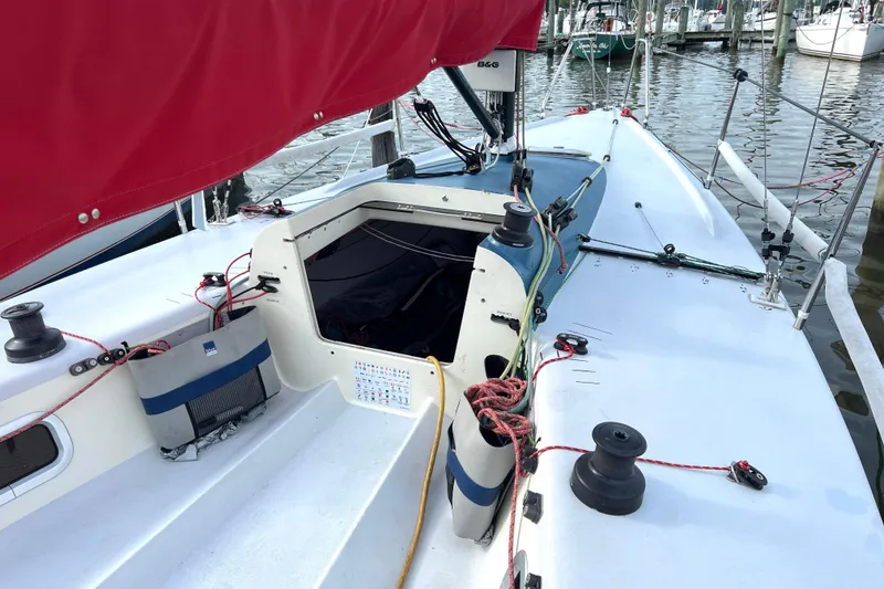 Slide: The Image of Sailboat deck view of 2015 Wraceboats GP26 with red sail and marina background. - 11