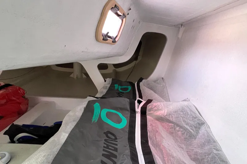 Slide: The Image of Interior of a 2015 Wraceboats GP26 sailboat, featuring storage bags and a small window. - 22