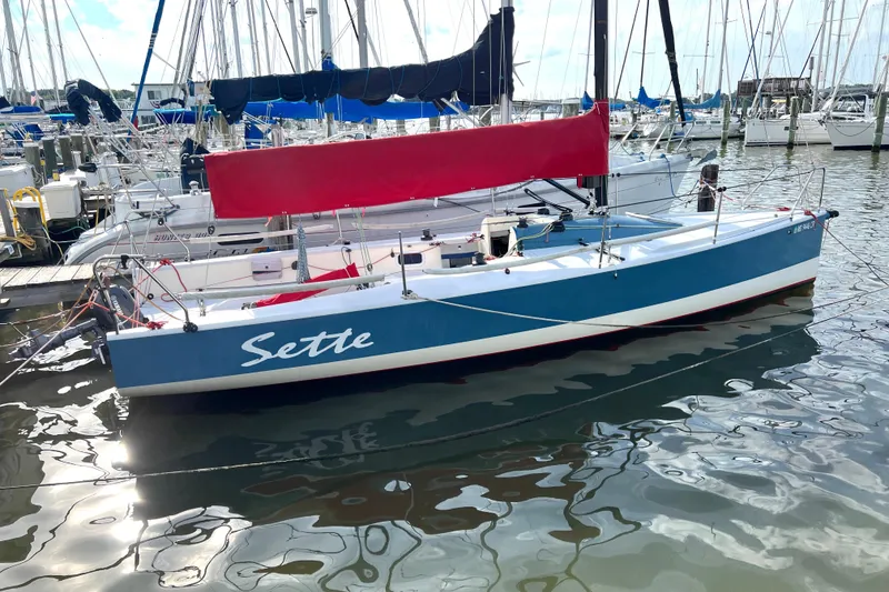 Slide: The Image of Blue and white 2015 Wraceboats GP26 sailboat named "Sette" docked in a marina. - 4
