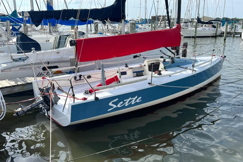Slide: The Image of Sailboat "Sette" docked, 2015 Wraceboats GP26, blue hull, red sail, marina background. - 6