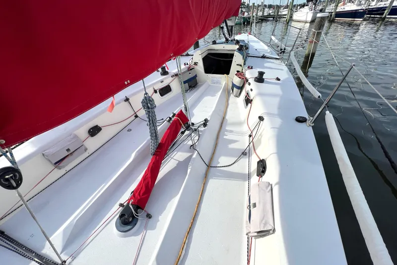 Slide: The Image of 2015 Wraceboats GP26 sailboat with red sail, docked at marina. - 8