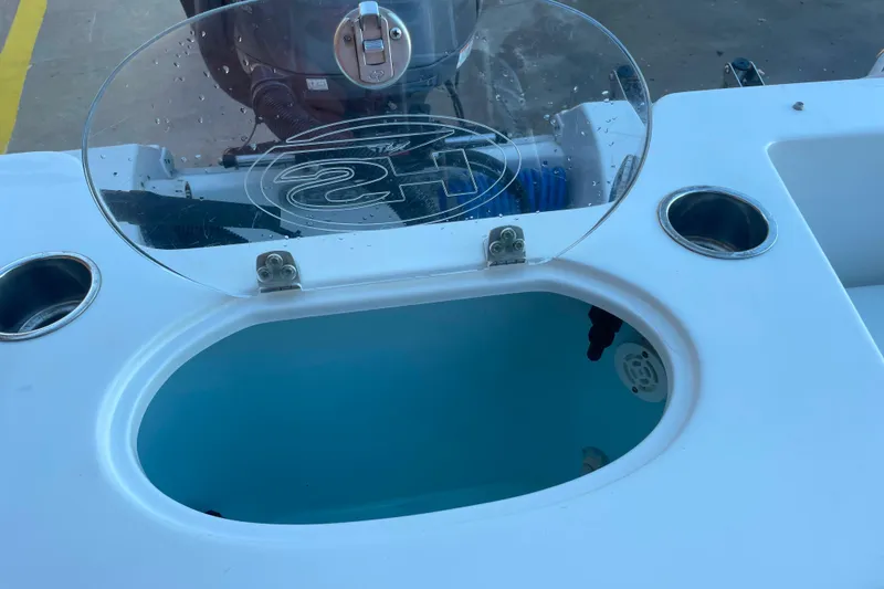 Slide: The Image of 2017 Sea Hunt Triton 210 boat livewell with open lid and cup holders. - 11