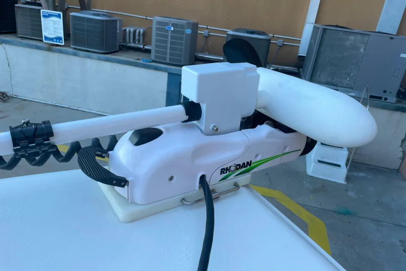 Slide: The Image of Rhodan trolling motor on 2017 Sea Hunt Triton 210 boat, docked near HVAC units. - 14