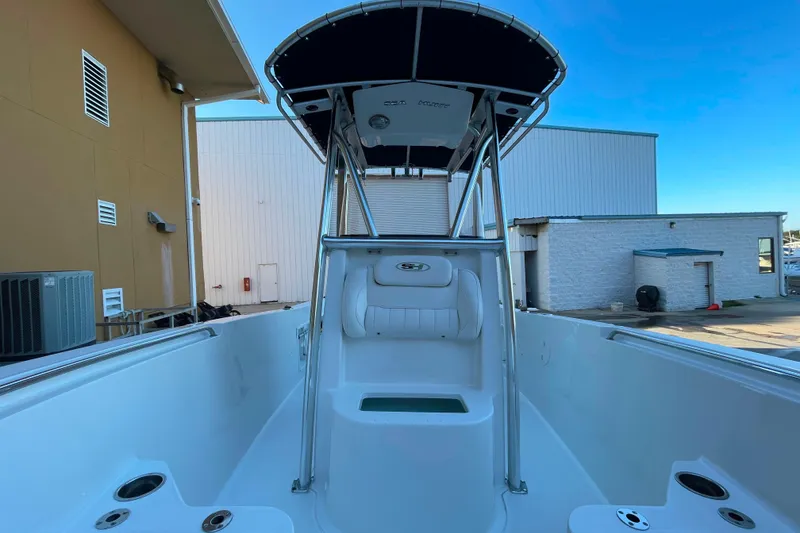 Slide: The Image of 2017 Sea Hunt Triton 210 boat with T-top, docked near industrial buildings. - 15
