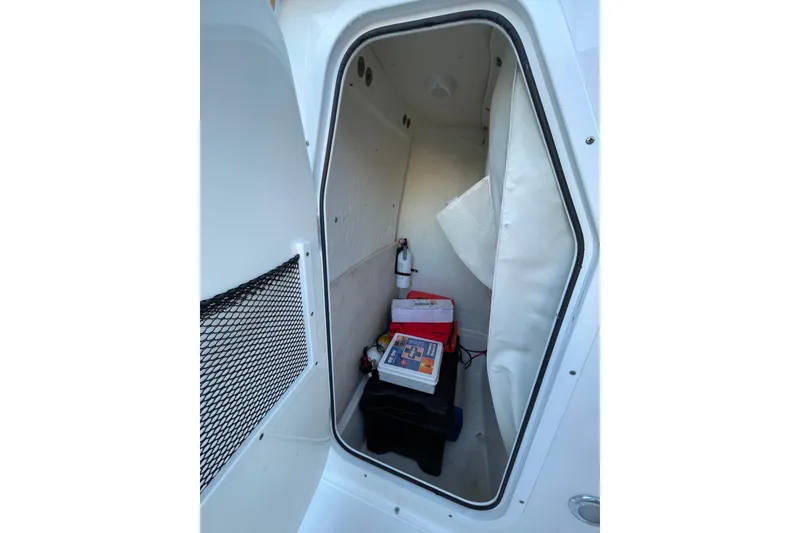 Slide: The Image of 2017 Sea Hunt Triton 210 storage compartment with safety equipment and supplies. - 16