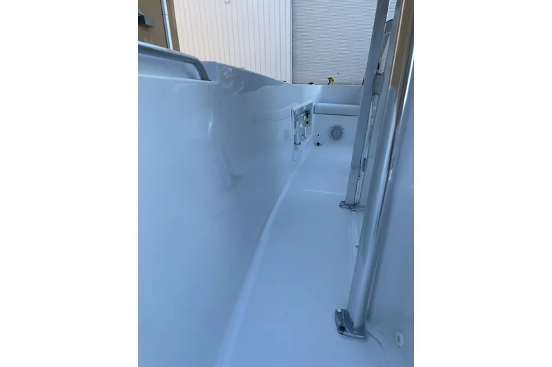 Slide: The Image of 2017 Sea Hunt Triton 210 boat interior, showcasing sleek white design and sturdy metal fixtures. - 18