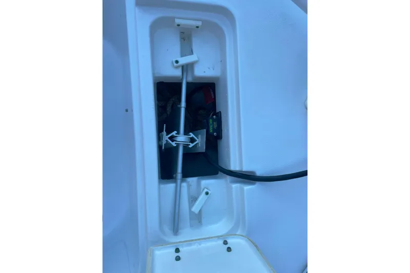 Slide: The Image of Storage compartment of a 2017 Sea Hunt Triton 210 boat, featuring an anchor and equipment. - 20