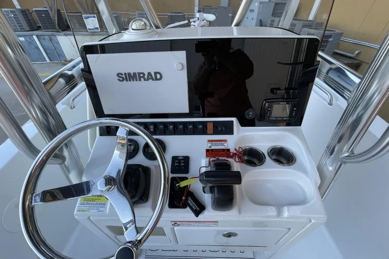 Slide: The Image of 2017 Sea Hunt Triton 210 boat console with Simrad display and steering wheel. - 3