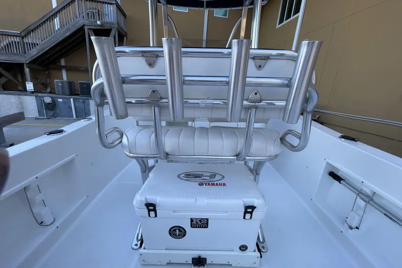 Slide: The Image of 2017 Sea Hunt Triton 210 boat interior with rod holders and cooler. - 9