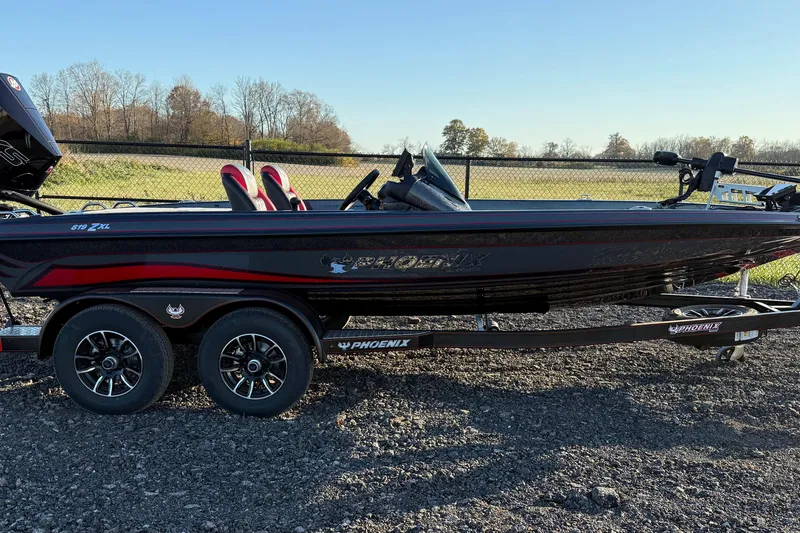 The Image of 2026 Phoenix 819 ZXL boat on trailer, black and red design, parked outdoors. - 1