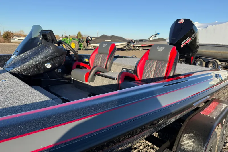 Slide: The Image of 2026 Phoenix 819 ZXL boat with sleek design and red-accented seats, parked outdoors. - 7