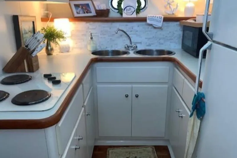 Slide: The Image of Compact kitchen in a 1994 Carver 440 Aft Cabin Motor Yacht, featuring modern appliances. - 5