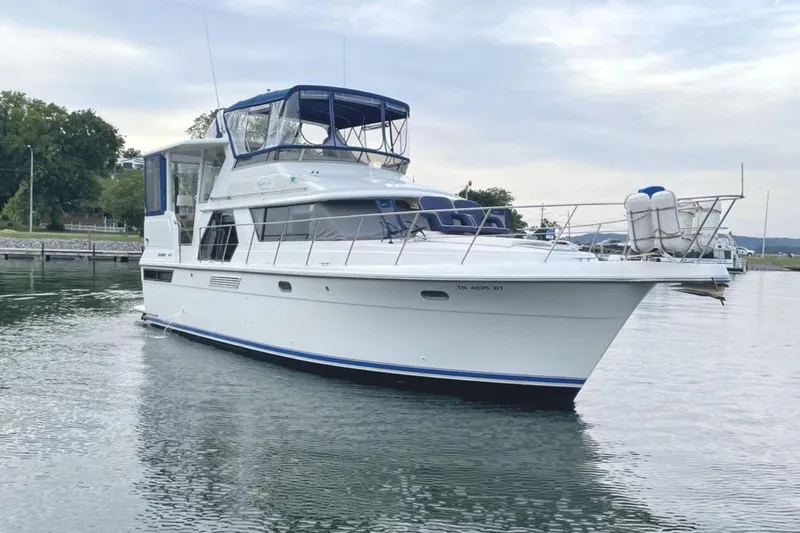 The Image of 1994 Carver 440 Aft Cabin Motor Yacht on calm water, featuring sleek design and spacious deck. - 0