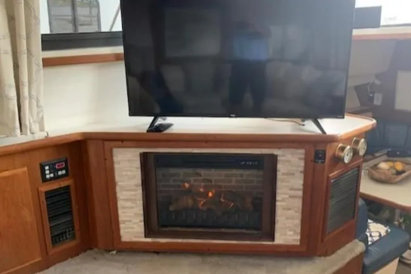 Slide: The Image of 1994 Carver 440 Aft Cabin Motor Yacht interior with TV and fireplace. - 3