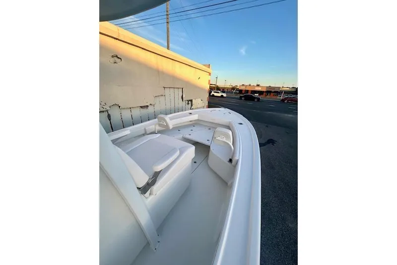Slide: The Image of 2026 Pair Customs 24 Center Console MV boat, white interior, parked outdoors at sunset. - 10
