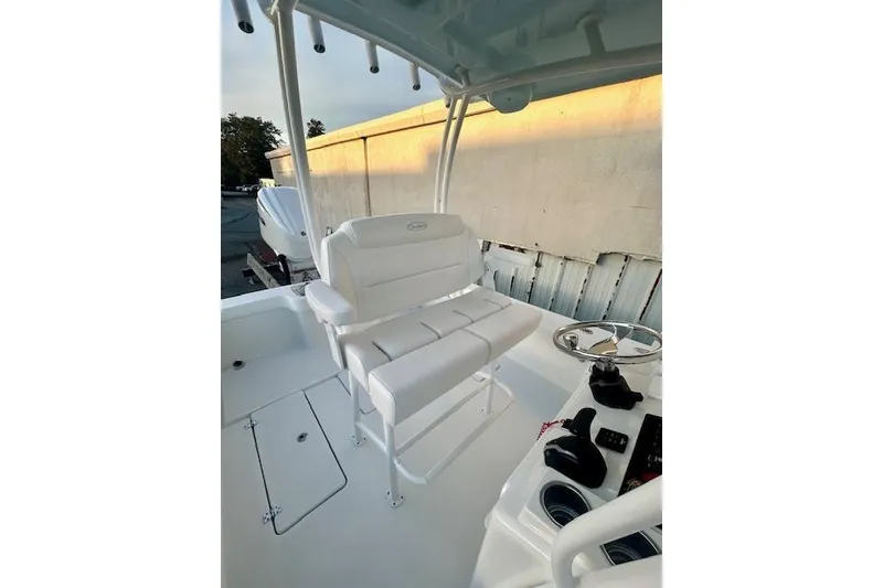 Slide: The Image of 2026 Pair Customs 24 Center Console MV boat interior with white seating and steering wheel. - 17