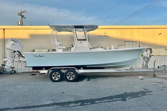 Slide: The Image of 2026 Pair Customs 24 Center Console MV boat on trailer, parked outdoors. - 3