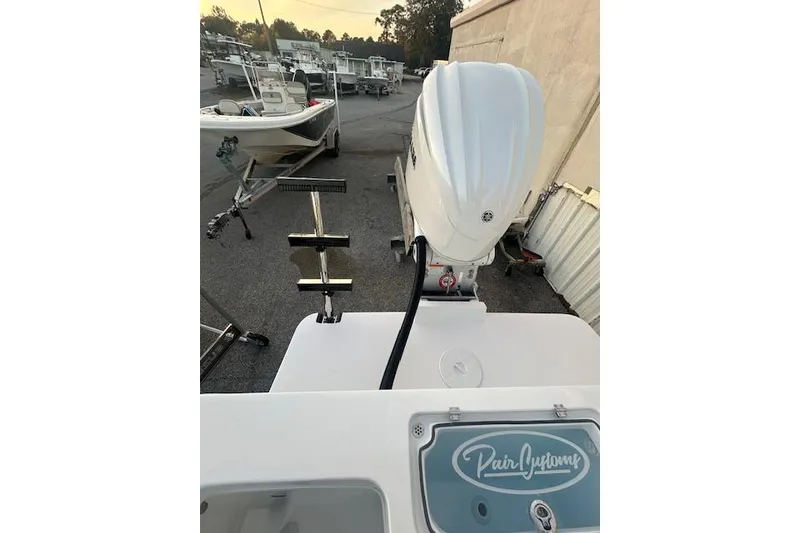 Slide: The Image of 2026 Pair Customs 24 Center Console MV boat with outboard motor in a marina setting. - 5