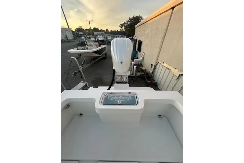 Slide: The Image of 2026 Pair Customs 24 Center Console MV boat with outboard motor in a marina setting. - 6