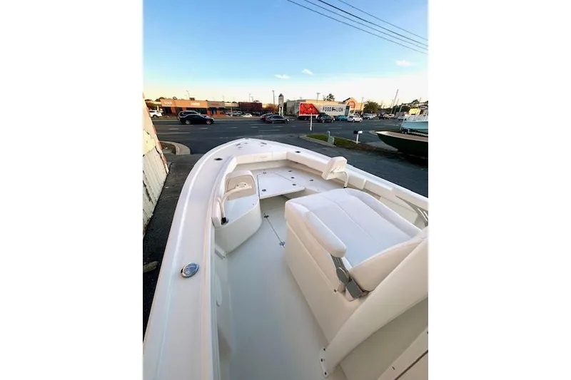 Slide: The Image of 2026 Pair Customs 24 Center Console MV boat, white interior, parked near a street. - 9