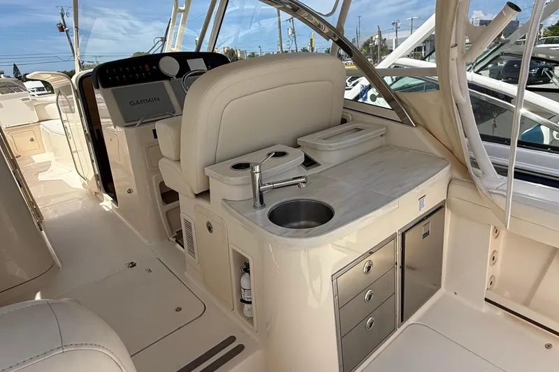 Slide: The Image of 2023 Grady-White Freedom 335 boat interior with sink, storage, and Garmin navigation system. - 24