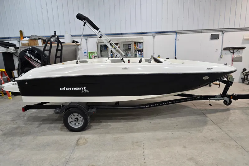 Slide: The Image of 2016 Bayliner Element XL boat on trailer in indoor storage. - 16