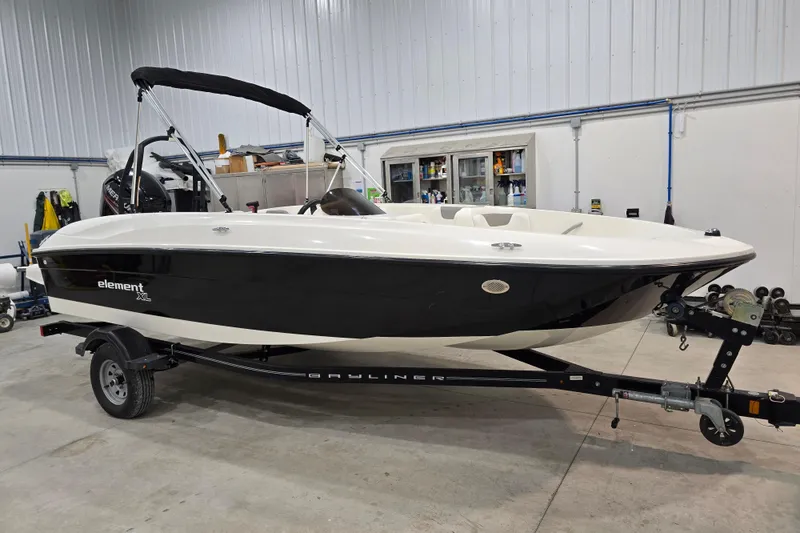 Slide: The Image of 2016 Bayliner Element XL boat in a garage, black and white design, on a trailer. - 17