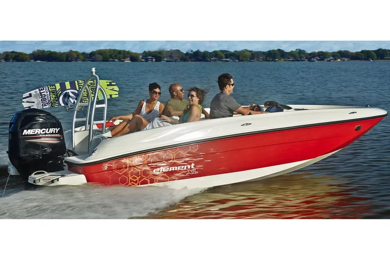 Slide: The Image of 2016 Bayliner Element XL boat on trailer, parked outdoors under cloudy sky. - 2