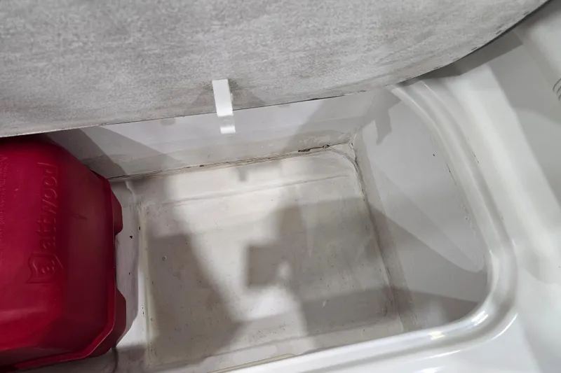 Slide: The Image of Storage compartment in a 2016 Bayliner Element XL boat with red Attwood container. - 53