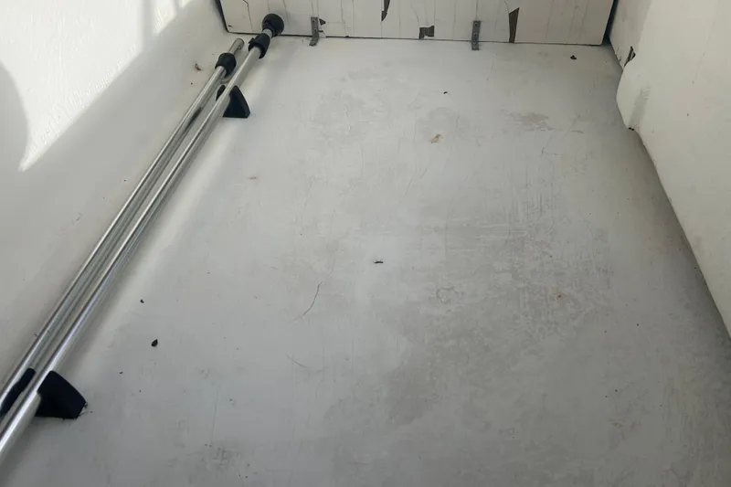 Slide: The Image of 2016 Bayliner Element XL interior storage compartment with metal poles. - 54