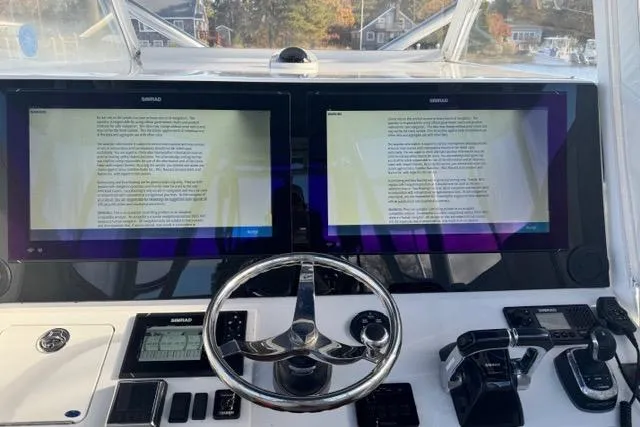 Slide: The Image of 2015 SeaHunter Center Console helm with dual Simrad displays and modern controls. - 6