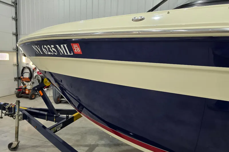Slide: The Image of 2014 Larson All American 23 boat in garage, blue and white hull, registration NY 6235 ML. - 10