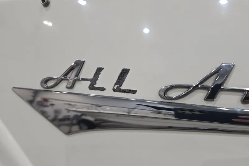 Slide: The Image of Close-up of 2014 Larson All American 23 boat emblem, featuring sleek chrome lettering. - 11