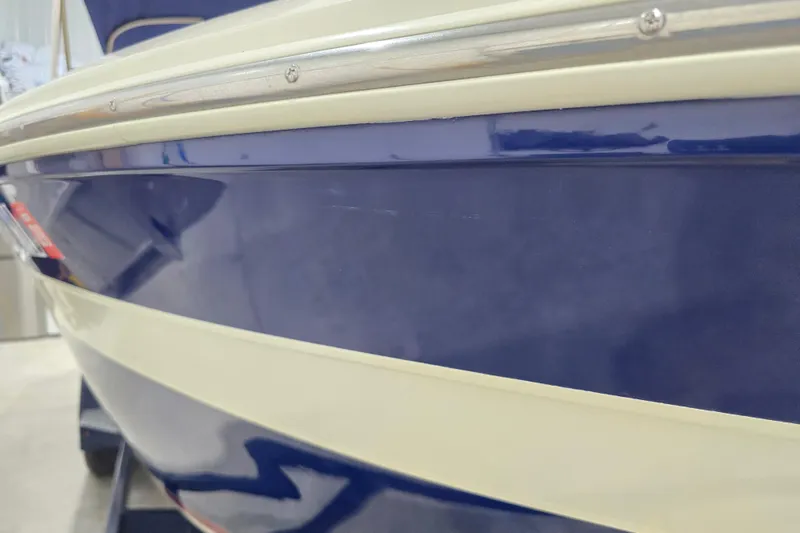 Slide: The Image of 2014 Larson All American 23 boat, close-up of blue and white hull detailing. - 17