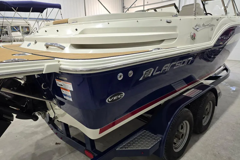 Slide: The Image of 2014 Larson All American 23 boat on trailer in indoor storage. - 18